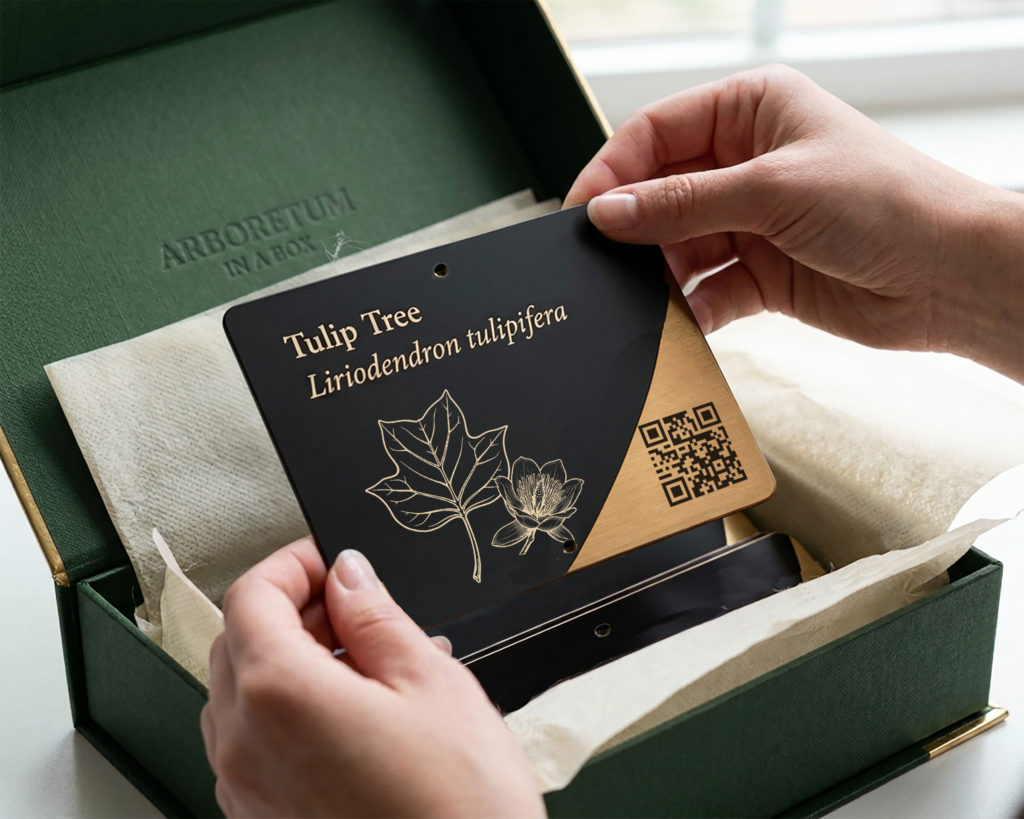 Dark green elegant box with metal arboretum signs wrapped in tissue paper.
